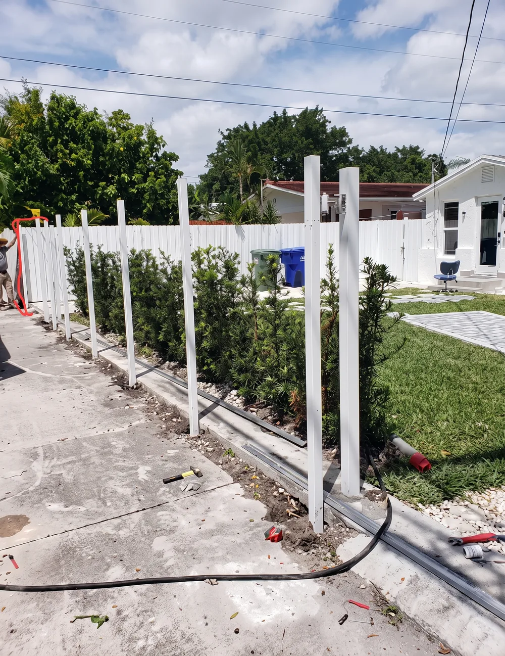 Postes de cerca recién instalados y alineados en el frente de una propiedad