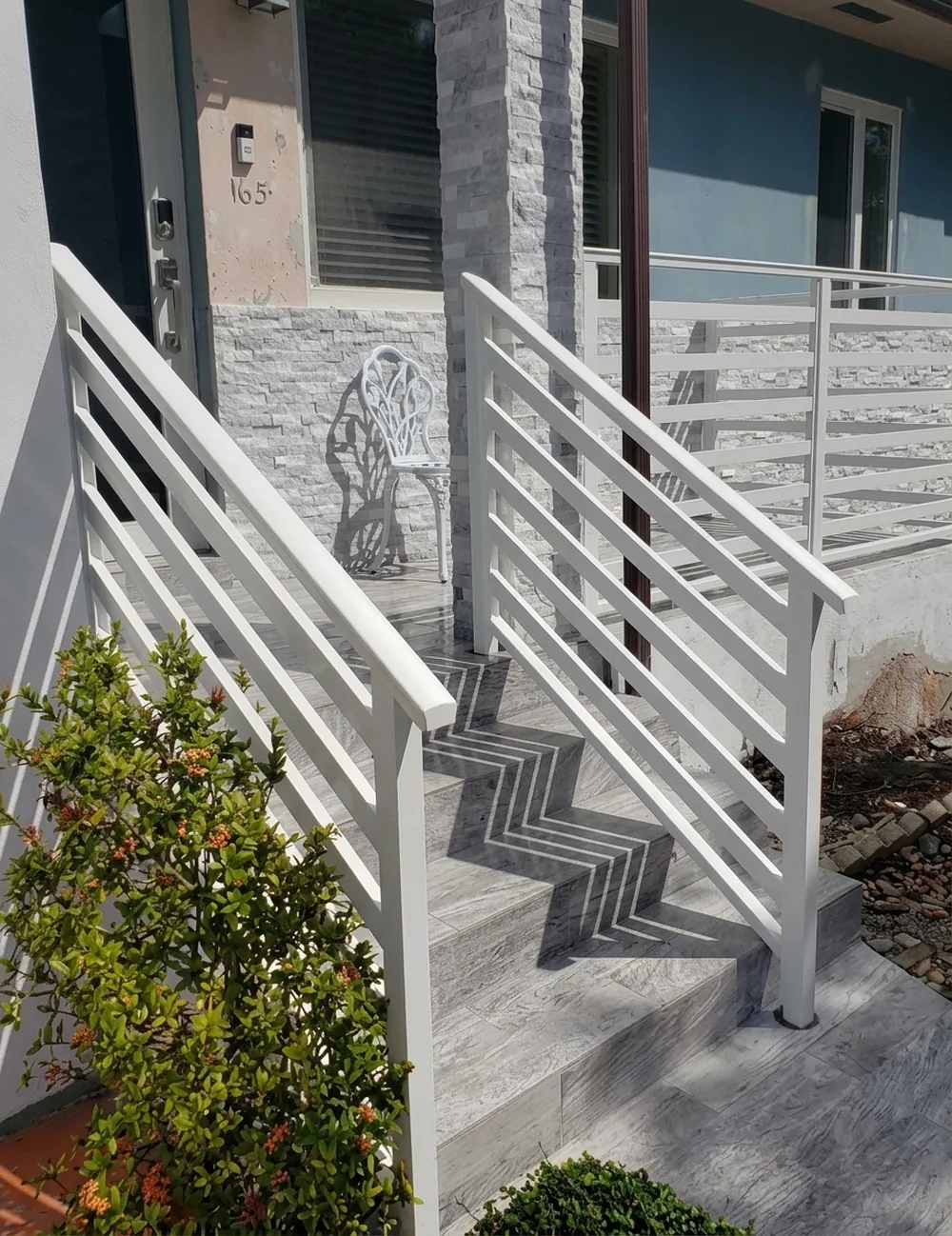 Baranda blanca de aluminio en la escalera exterior de una entrada