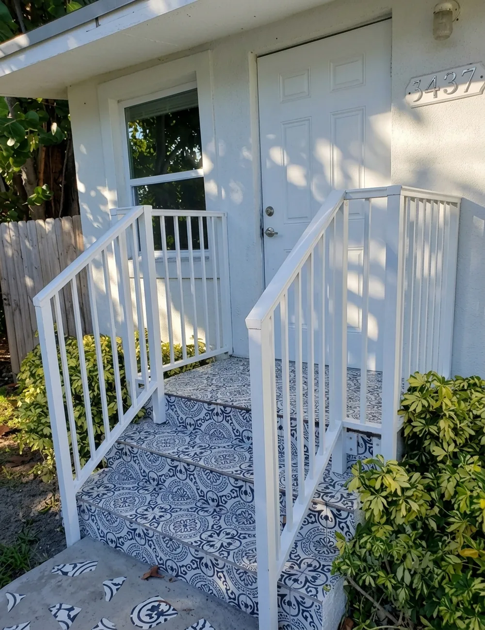 Baranda blanca de aluminio con pasamanos en la entrada de una casa