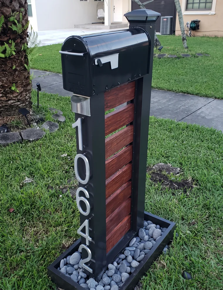 Buzón clásico negro sobre pedestal con panel de madera y número 10642