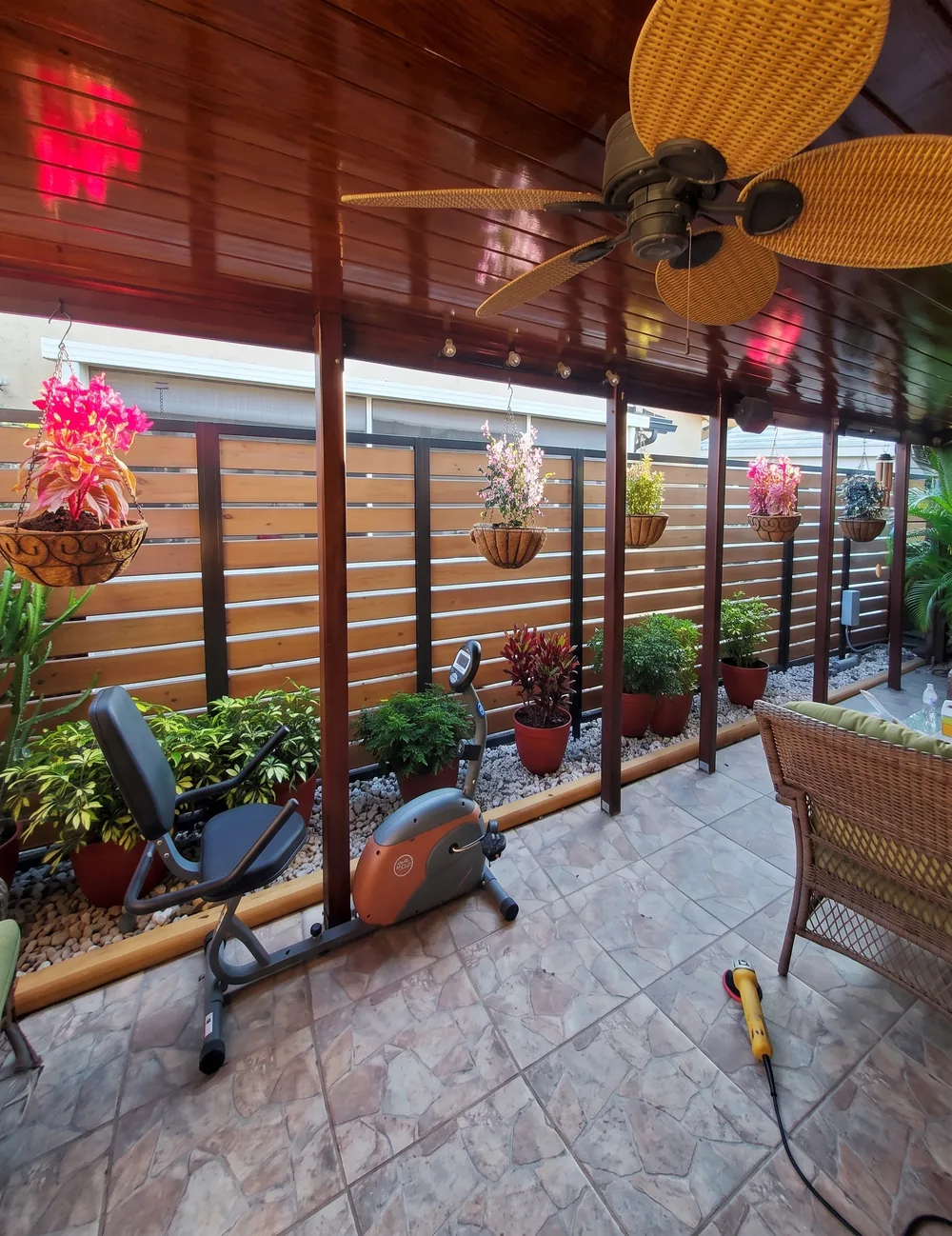 Cerramiento de lama de madera en una terraza techada con plantas