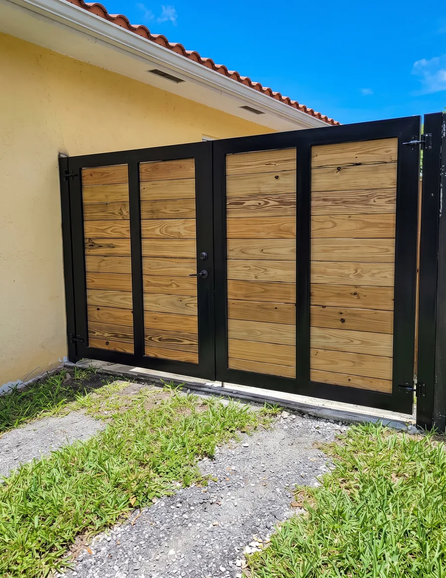 Portón doble de madera con marco metálico negro y puerta peatonal integrada