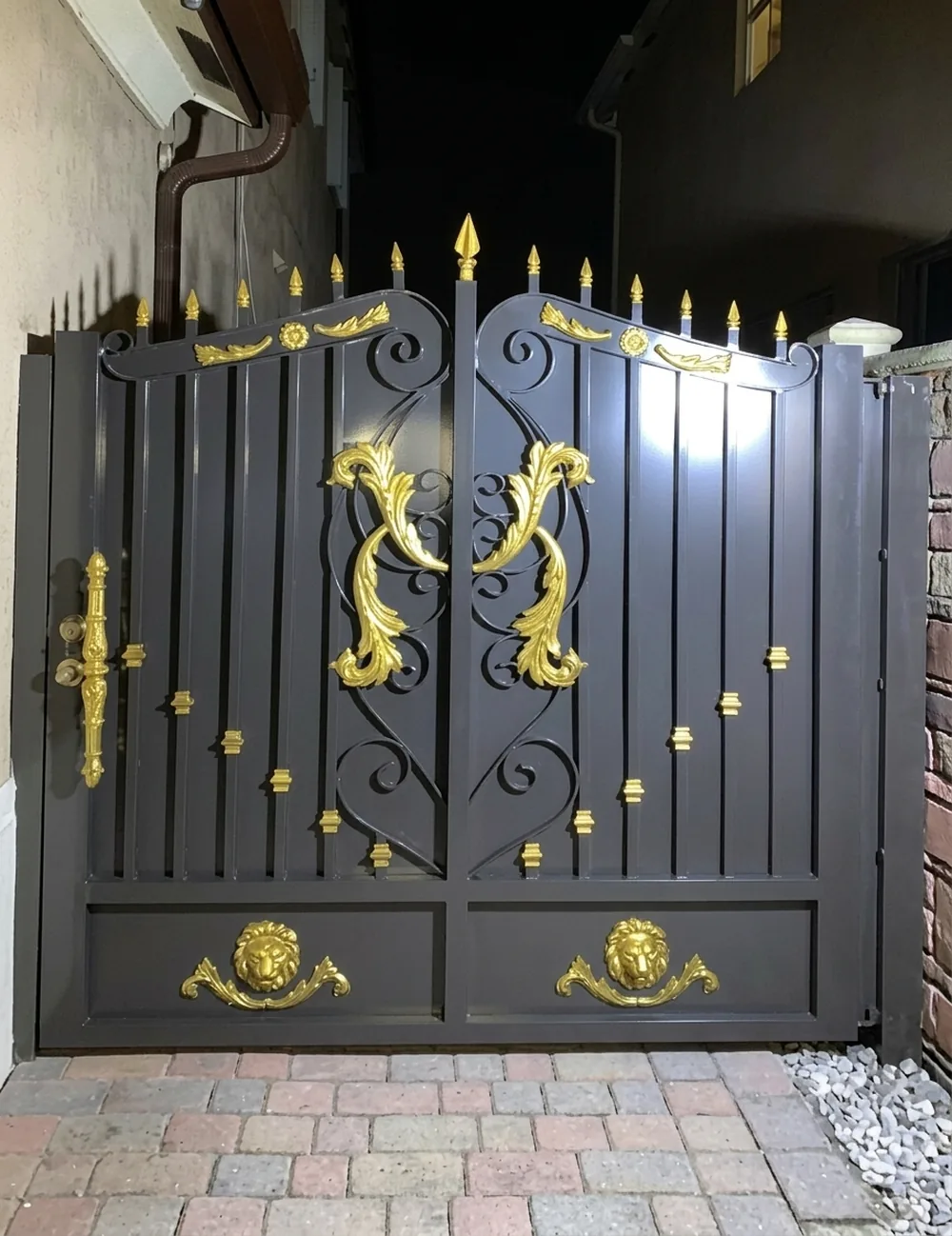 Puerta de hierro ornamental negra con apliques dorados y puntas de lanza