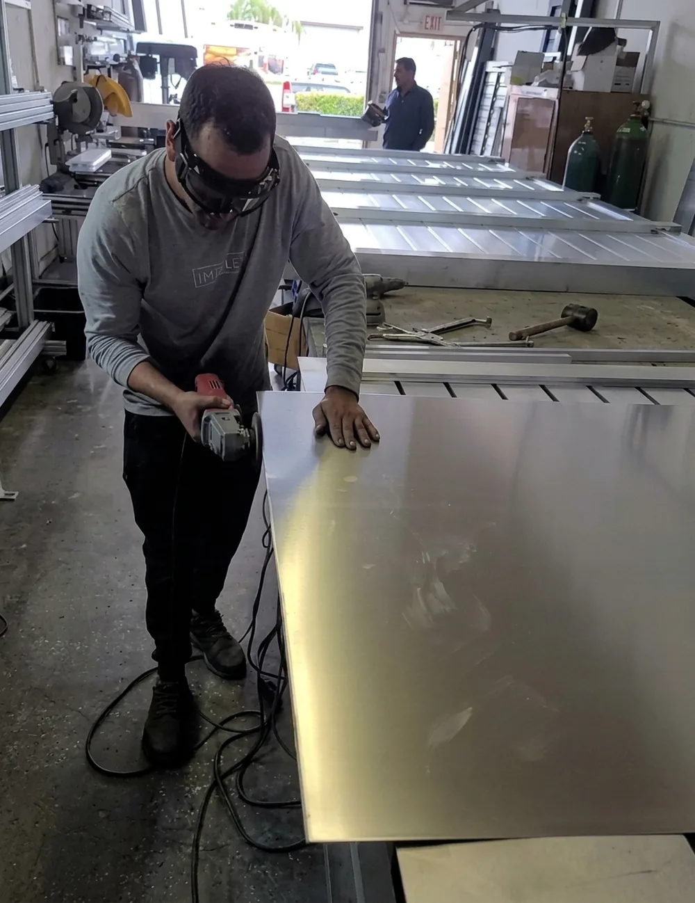 Operario puliendo una lámina de aluminio sobre la mesa de trabajo